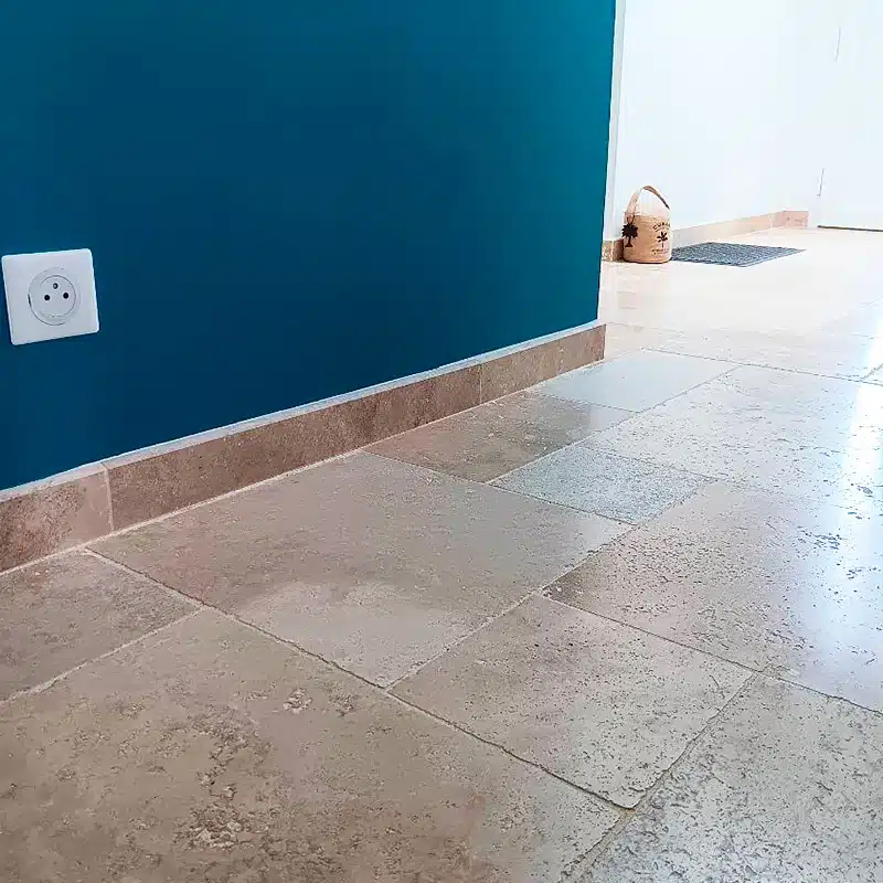 Entrée de maison avec des plinthes en travertin