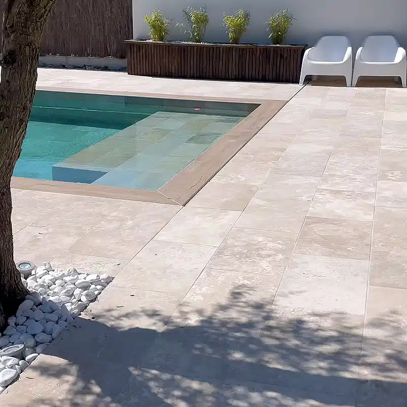 Jolie bord de piscine avec du dallage en travertin Mix 1er choix