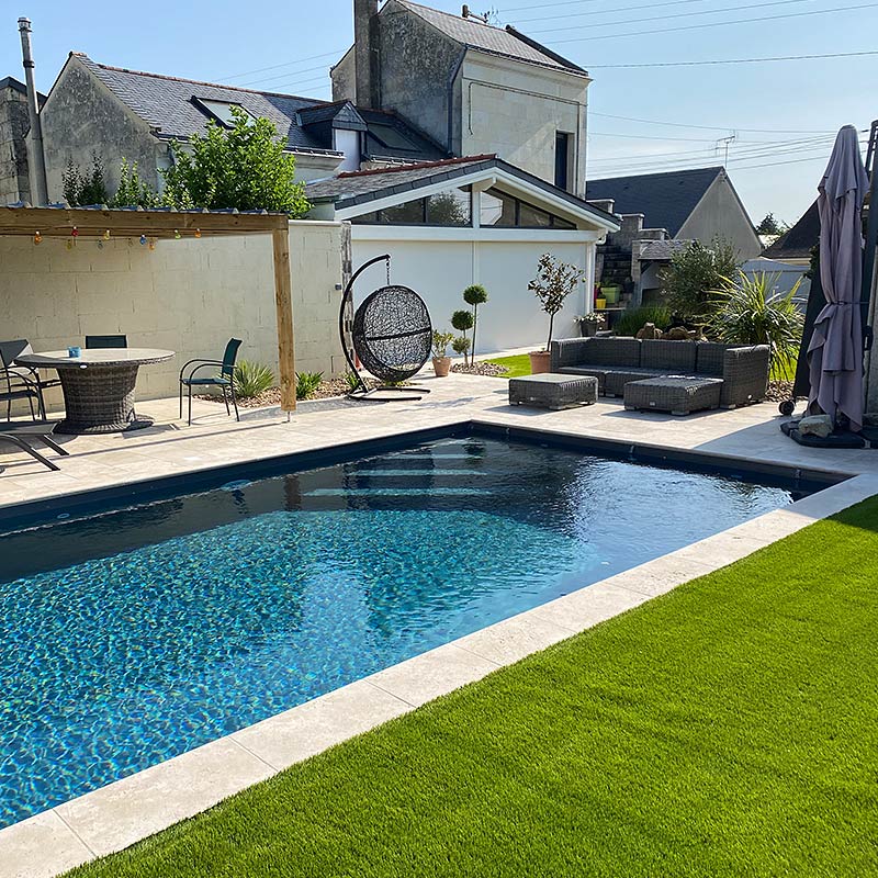 Piscine en Travertin avec du gazon synthétique
