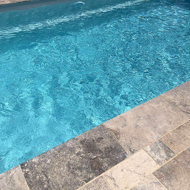 Piscine en Travertin gris avec des margelles